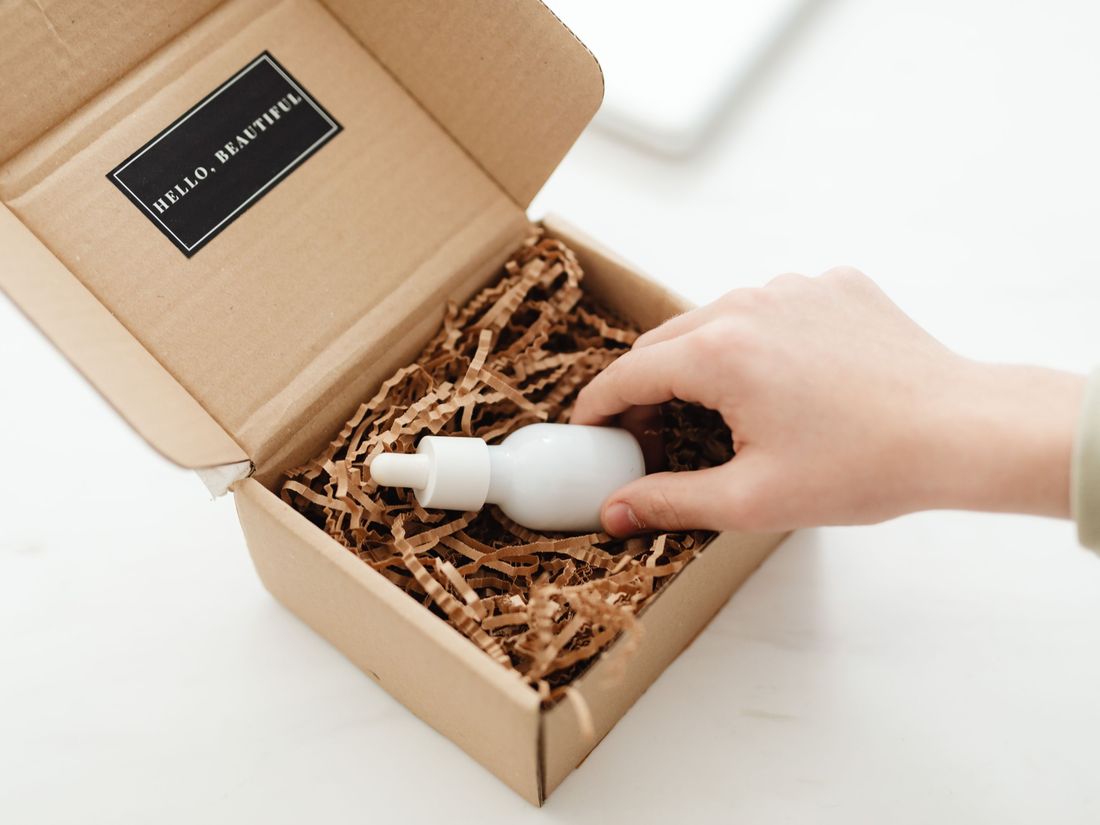 Hands packing a sealed unit into a shipping carton