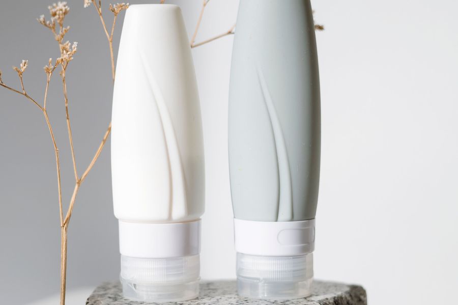 Two white pump bottles on a stone plinth