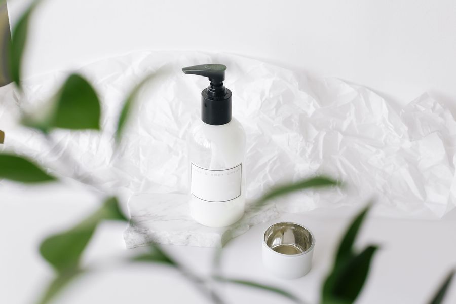 An unbranded white pump bottle on soft white fabric