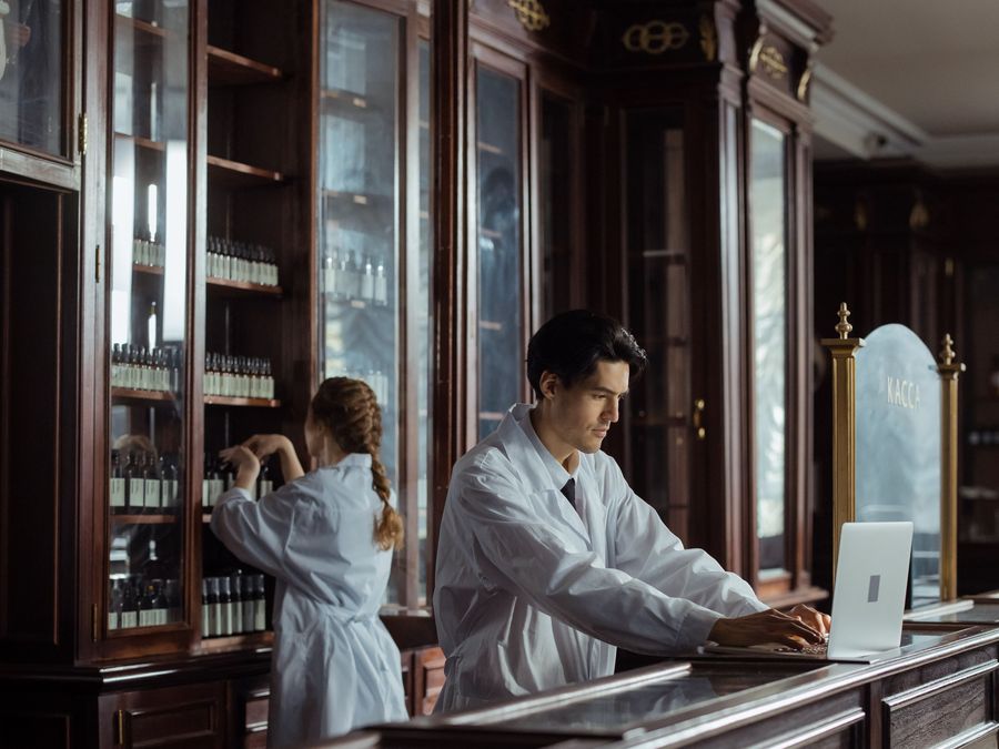Staff working behind a wooden pharmacy counter